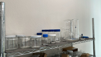 LOT OF (3) RACKS OF ASSORTED LABORATORY EQUIPMEMT, TO INCLUDE: SAFETY GLASSES, COTTON TIPPED APPLICATORS, LAB COATS, ASSORTED BEAKERS, ETC. - 2