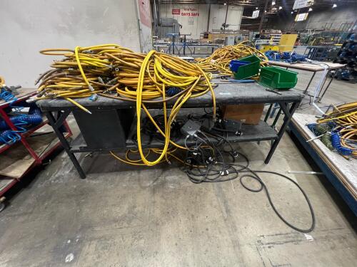 Assorted air compressor hoses / assorted electrical cords on industrial table